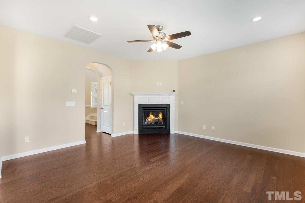 2433 Pilsley Road Apex, NC 27539 - Photo 8 of 28 a view of an empty room with wooden floor fireplace and a window