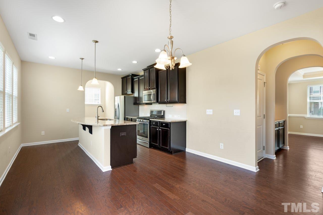 2433 Pilsley Road Apex, NC 27539 - Photo 9 of 28 a view of a kitchen with a sink a refrigerator and a stove top oven