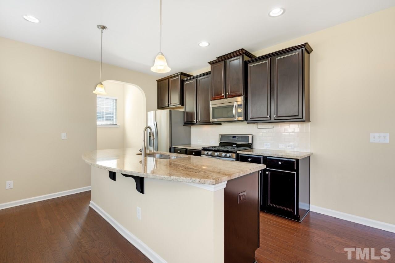 2433 Pilsley Road Apex, NC 27539 - Photo 10 of 28 a kitchen with stainless steel appliances granite countertop a sink a stove and a refrigerator