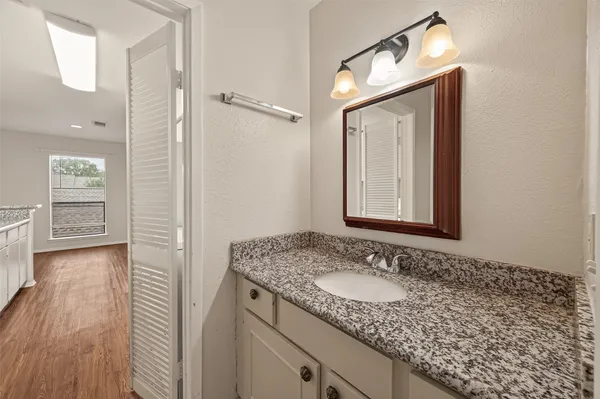 a bathroom with a granite countertop sink and a mirror
