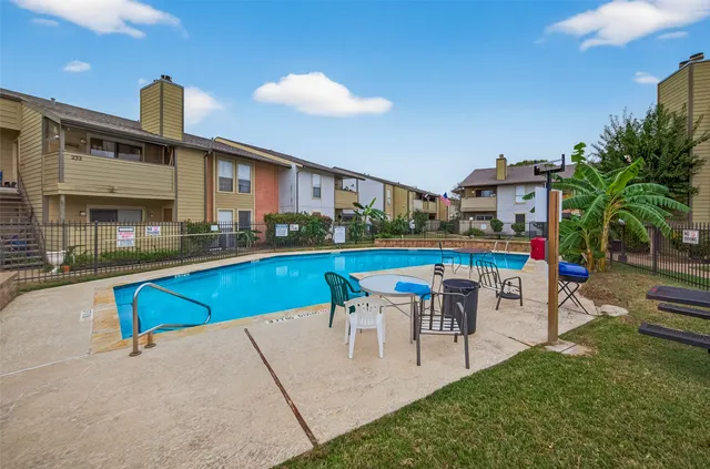 a view of a house with a yard plants and large tree