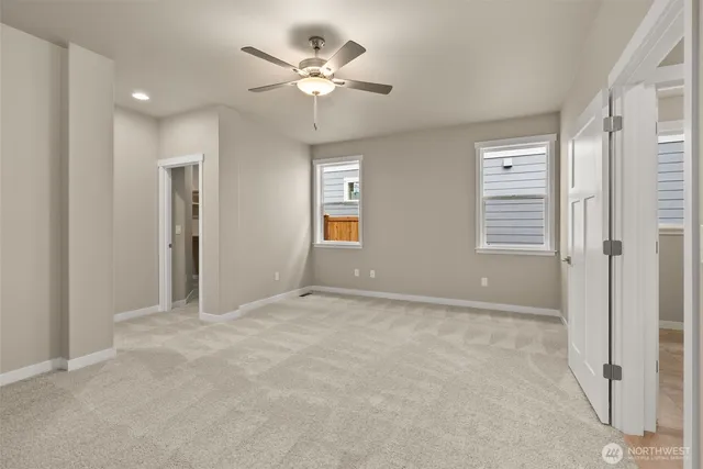 a spacious bedroom with a bed and a ceiling fan