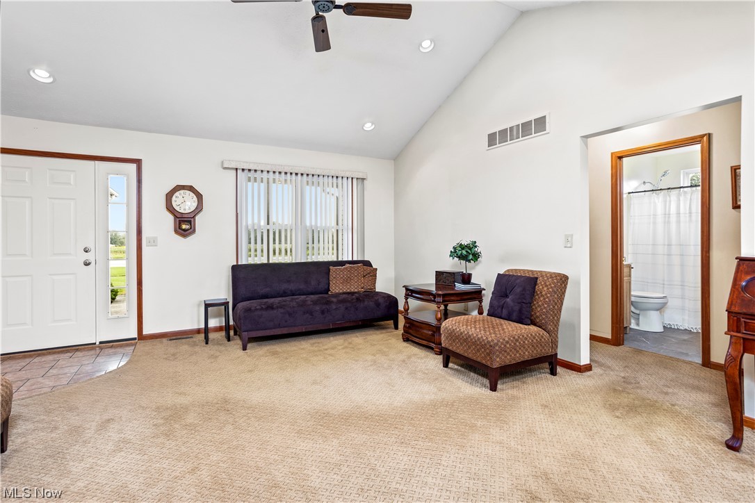 9240 Murray Ridge Road Elyria, OH 44035 - Photo 12 of 34 Carpeted living room featuring vaulted ceiling, a high ceiling, and ceiling fan