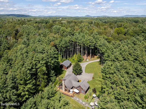 a aerial view of a house with table and chairs under an umbrella