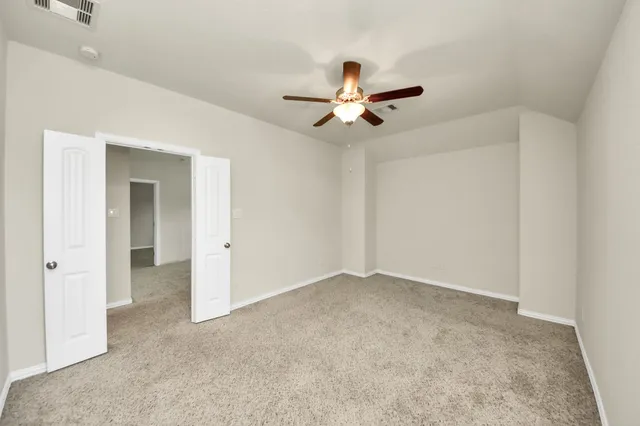 an empty room with a window and a fan