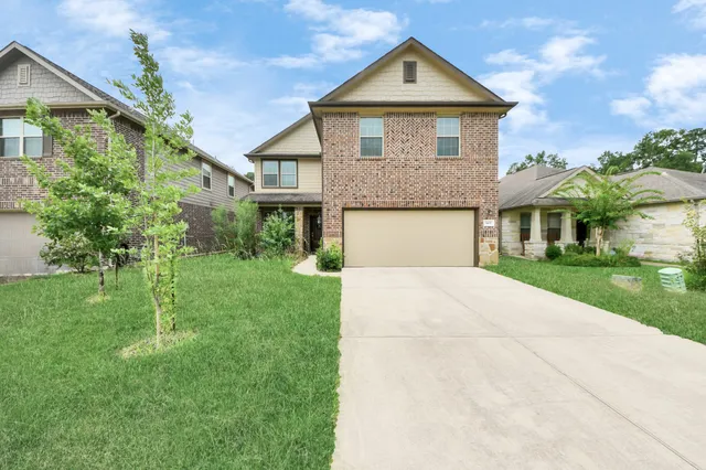 a front view of a house with a yard and garage