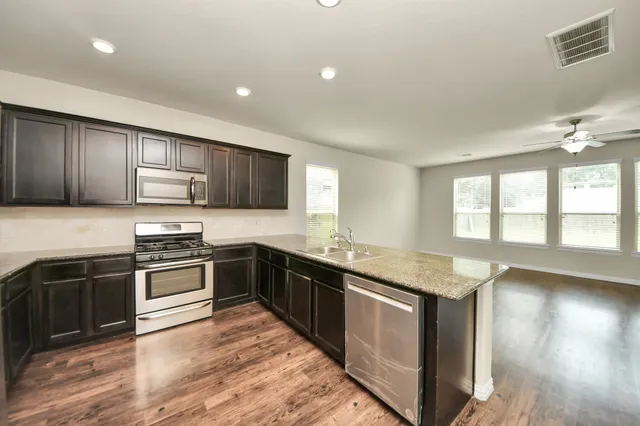 a kitchen with stainless steel appliances granite countertop a sink stove and refrigerator