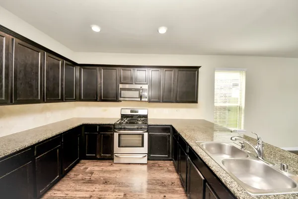 a kitchen with stainless steel appliances granite countertop a sink stove and refrigerator