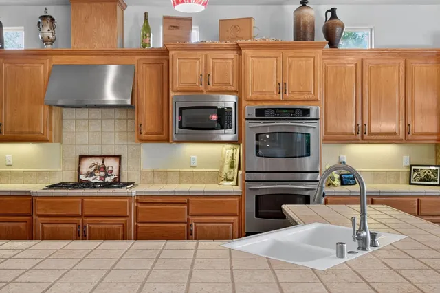 a spacious bathroom with a granite countertop tub a double vanity sink a mirror and a shower