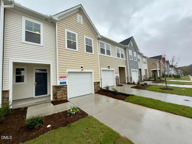 a view of a white house with a yard and table and chairs