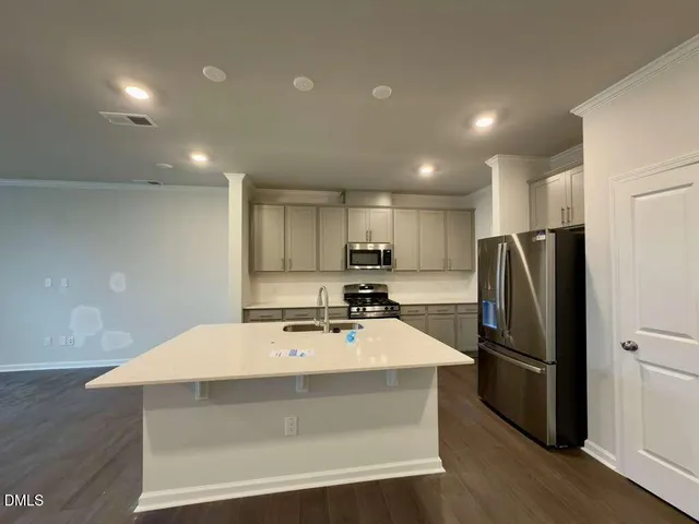 a kitchen with kitchen island a sink appliances and cabinets
