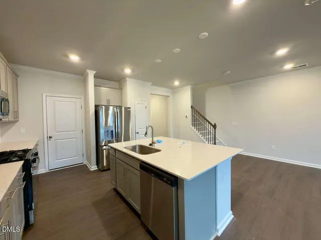 a kitchen with kitchen island a sink stove and refrigerator