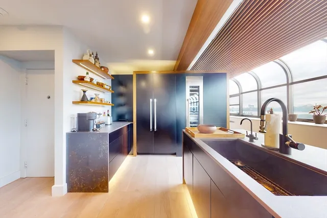 a large kitchen with stainless steel appliances granite countertop a sink and a refrigerator