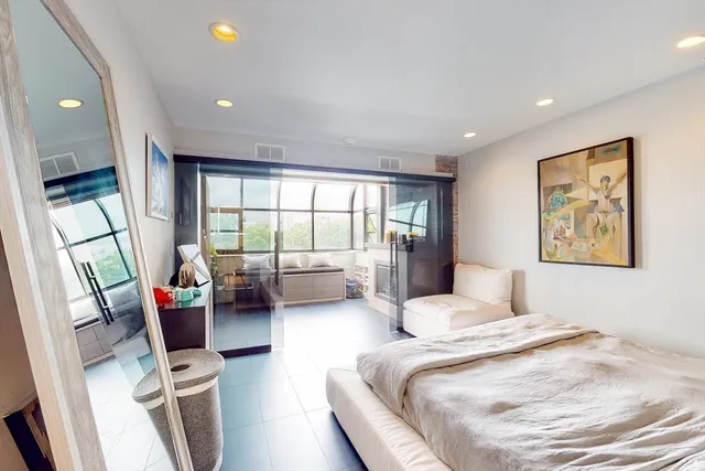 a bedroom with furniture and a large window