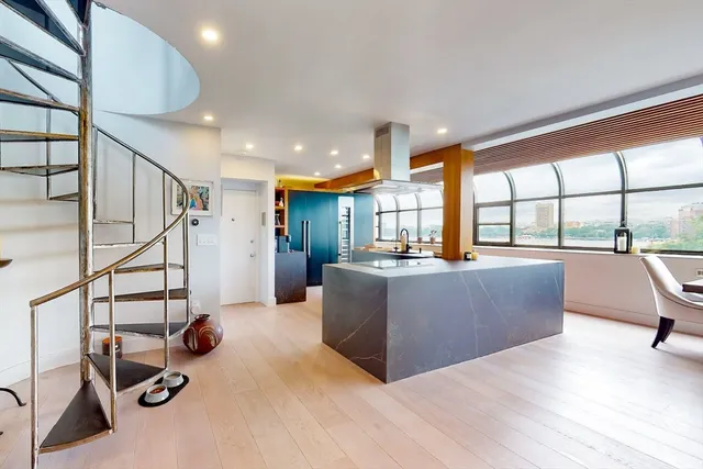 a living room with furniture floor to ceiling window and a wooden floor