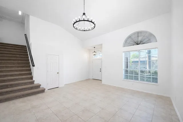 a view of an empty room with wooden floor and stairs