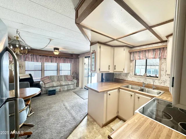 a living room with furniture a flat screen tv and kitchen view