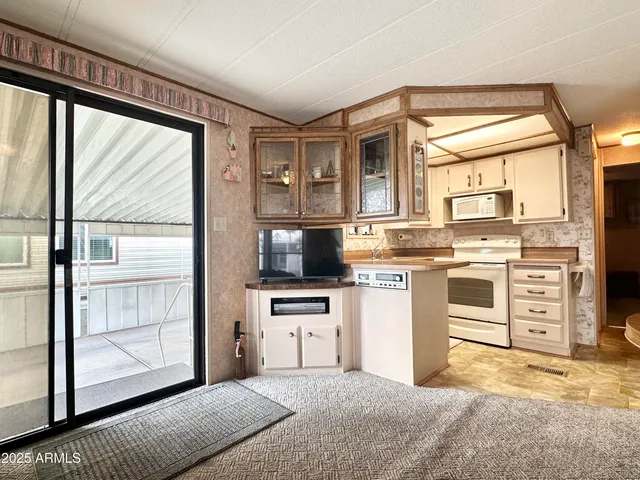 a living room with furniture a flat screen tv and a floor to ceiling window