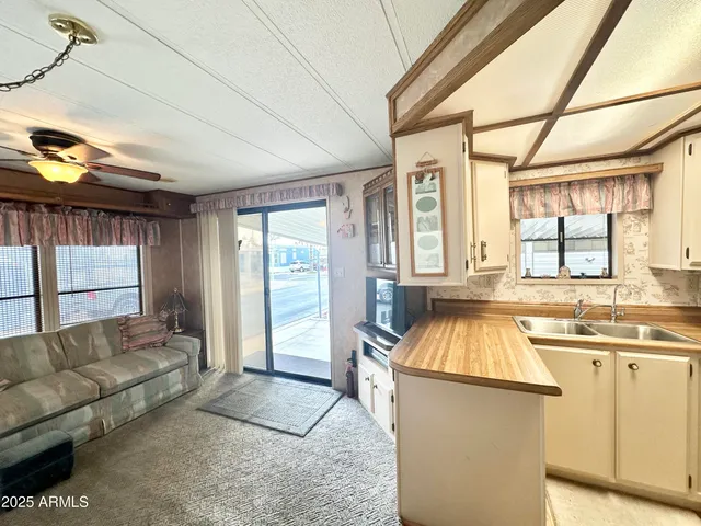 a living room with furniture a flat screen tv and a floor to ceiling window