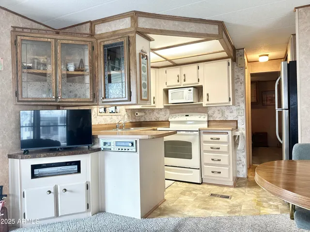 a kitchen that has a sink a stove and cabinets