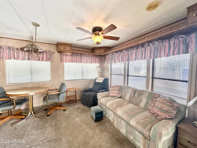 a living room with furniture a ceiling fan and a window