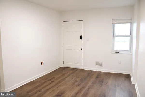 an empty room with wooden floor and white walls