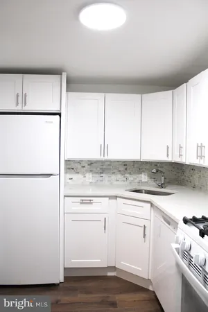 a kitchen with a refrigerator sink stove and cabinets