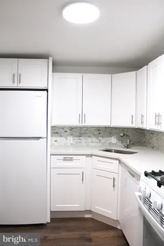 a kitchen with a refrigerator sink stove and cabinets