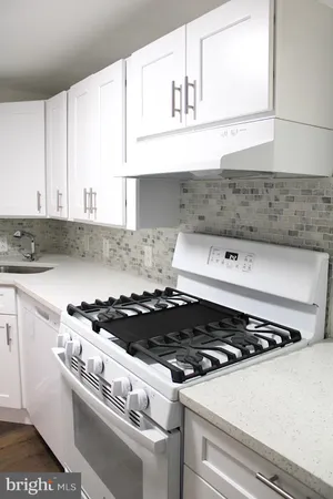a stove top oven sitting inside of a kitchen