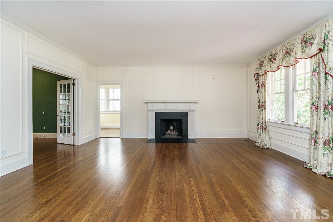 1621 St Marys Street Raleigh, NC 27608 - Photo 3 of 25 an empty room with wooden floor fireplace and windows