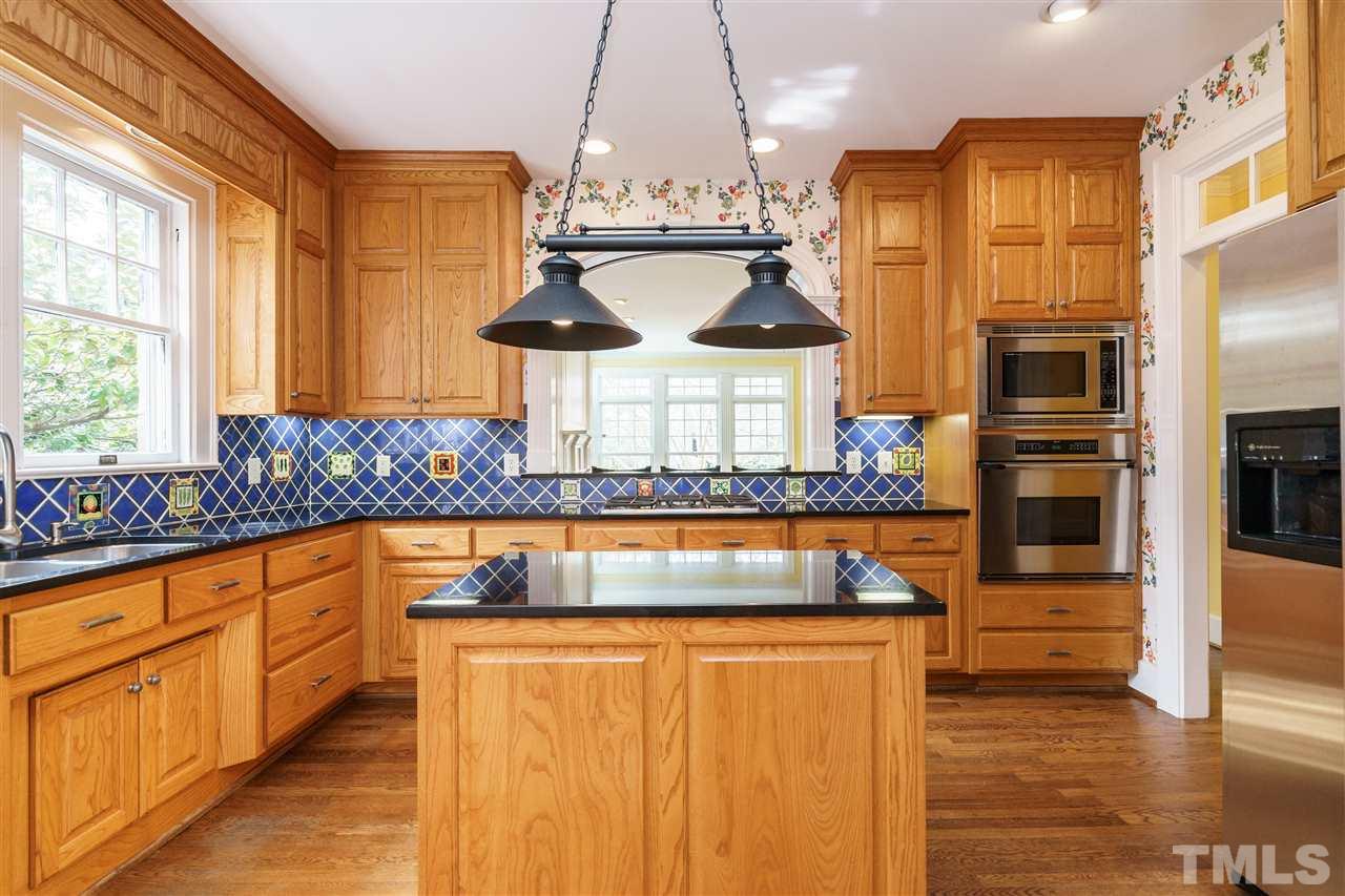 1621 St Marys Street Raleigh, NC 27608 - Photo 7 of 25 a kitchen with stainless steel appliances granite countertop a stove and a refrigerator