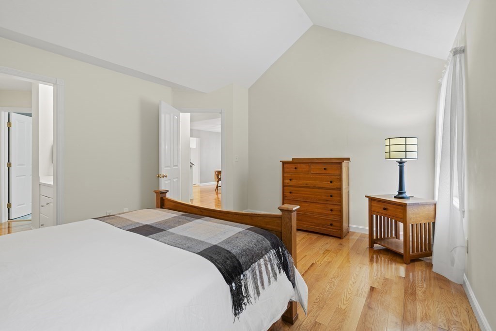 4 Strawberry Lane, Unit E Hudson, MA 01749 - Photo 11 of 40 a bedroom with a bed and wooden floor