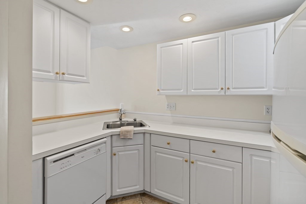 4 Strawberry Lane, Unit E Hudson, MA 01749 - Photo 6 of 40 a kitchen with white cabinets and white appliances