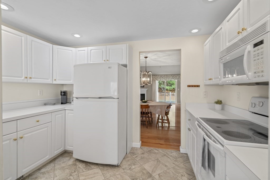 4 Strawberry Lane, Unit E Hudson, MA 01749 - Photo 9 of 40 a kitchen with white cabinets and white appliances