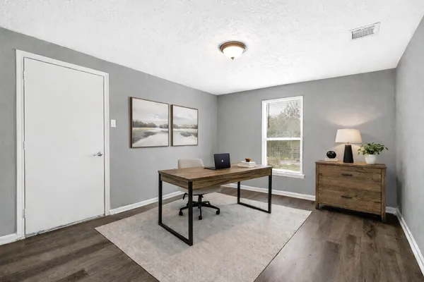 a view of a workspace with furniture and a window