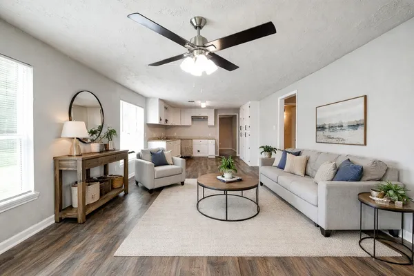 a living room with furniture a rug and a ceiling fan