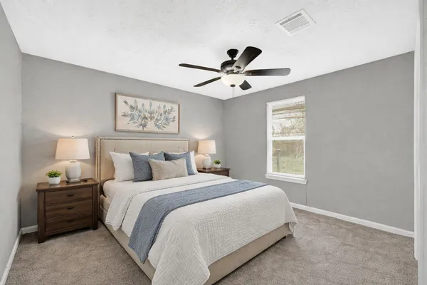 a bedroom with a large bed and a window