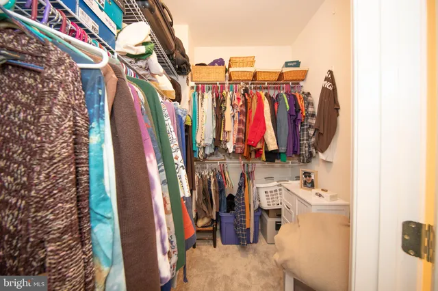 a view of walk in closet with clothes