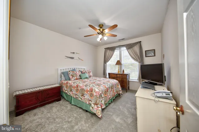a bedroom with a bed and a flat tv screen on the dresser