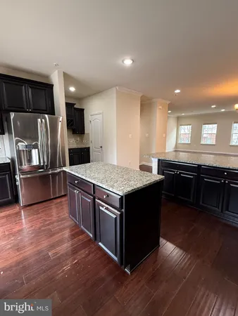 a kitchen with stainless steel appliances kitchen island granite countertop a stove a sink and a microwave
