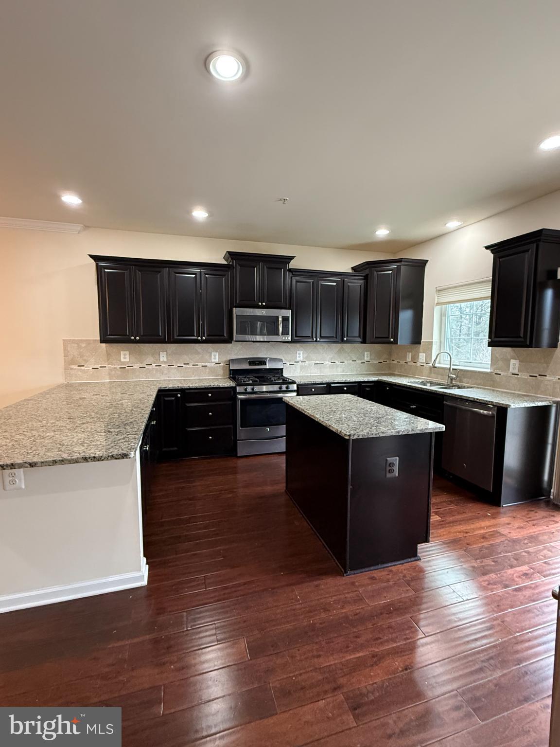 7018 Foxton Way Hanover, MD 21076 - Photo 17 of 72 Modern kitchen with sleek dark cabinetry.