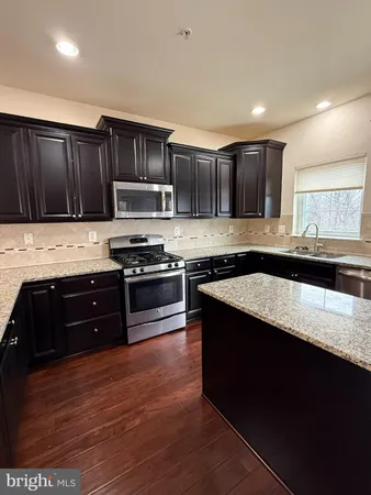 a kitchen with stainless steel appliances granite countertop a refrigerator and a stove