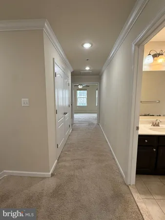 a view of an empty room with a chandelier fan
