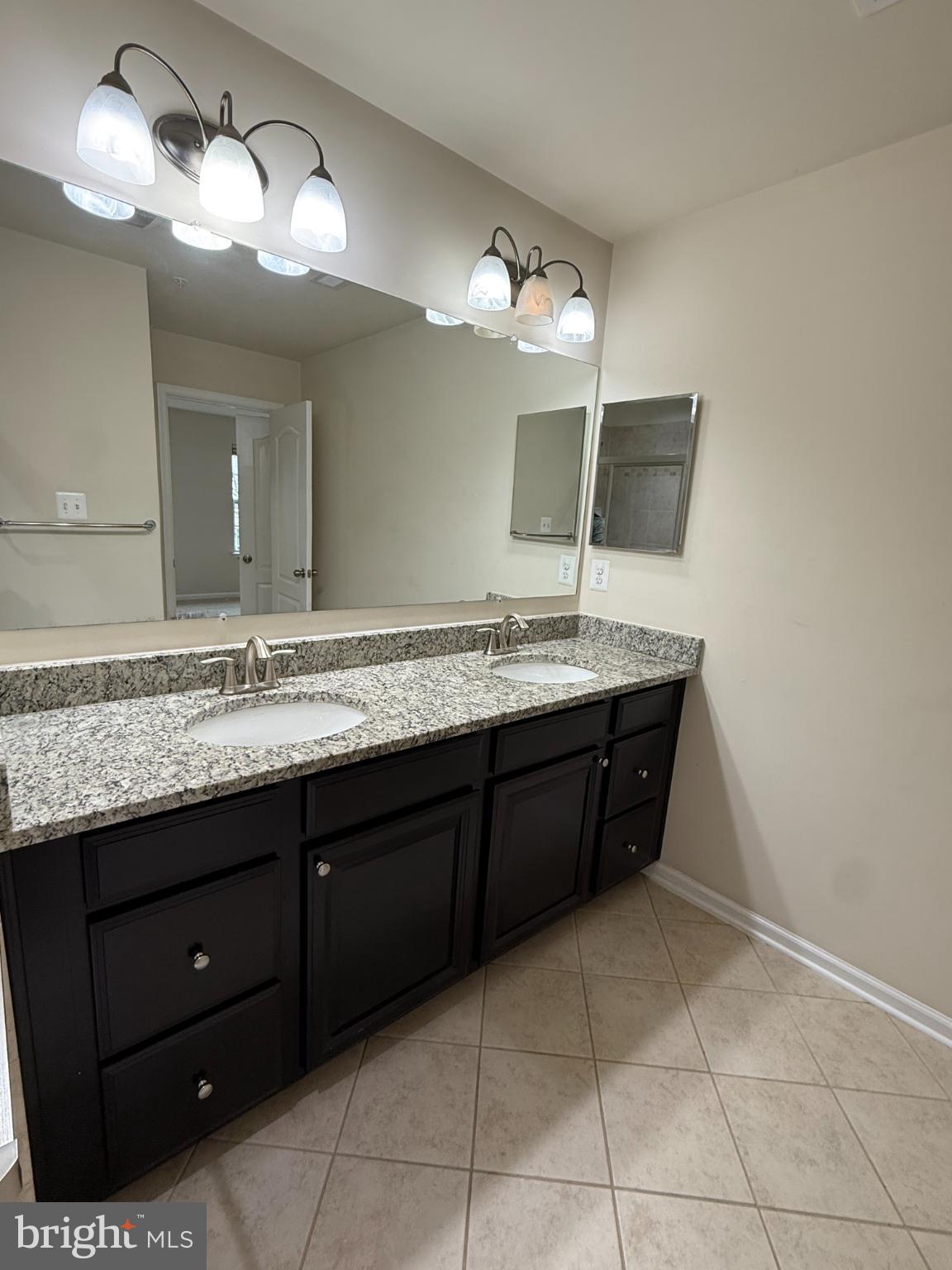 7018 Foxton Way Hanover, MD 21076 - Photo 41 of 72 a spacious bathroom with a granite countertop sink and a mirror