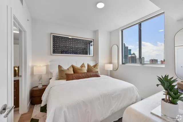 a bedroom with a large bed and a potted plant