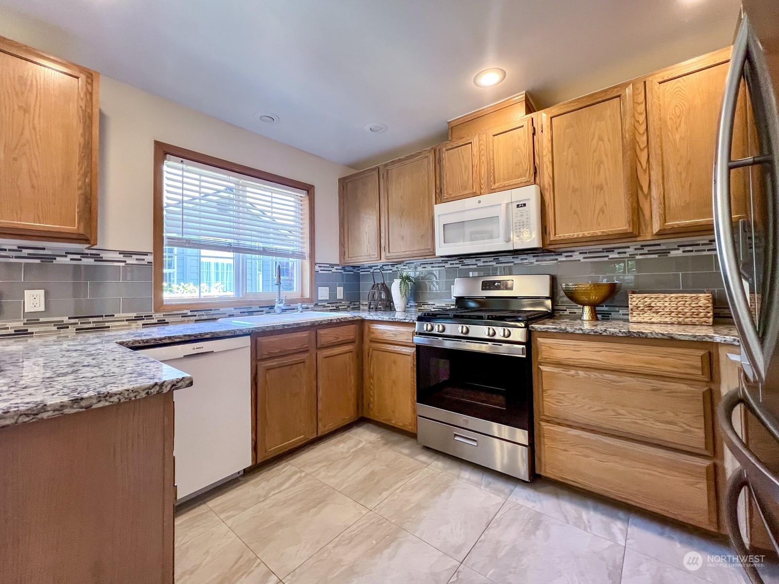 4019 Northeast 17th Street Renton, WA 98056 - Photo 12 of 37 a kitchen with stainless steel appliances granite countertop a stove a sink and a microwave