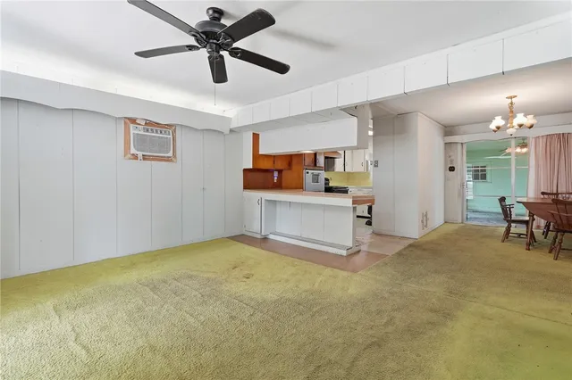 a view of a livingroom with a ceiling fan a kitchen a sink a ceiling fan and a rug