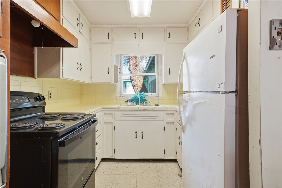 301 Laurel Street Fulton, TX 78382 - Photo 10 of 20 a kitchen with stainless steel appliances white cabinets and wooden floor