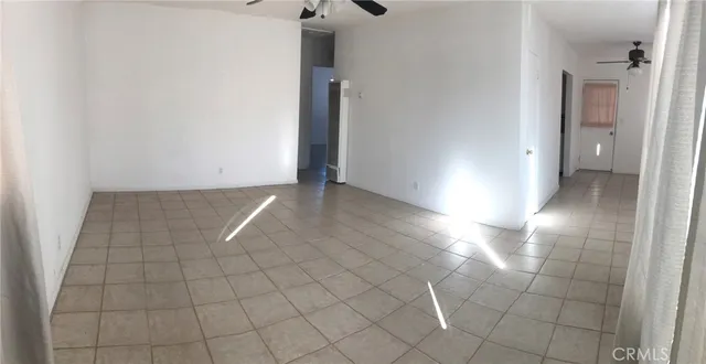 an empty room with a window and wooden floor