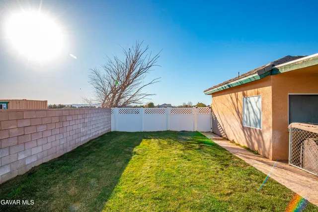 a kitchen with stainless steel appliances granite countertop a refrigerator a sink dishwasher a stove and white countertops with wooden floor